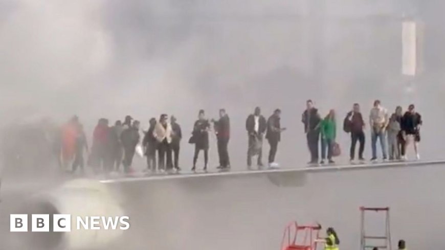 Passengers evacuate onto wing of burning American Airlines jet